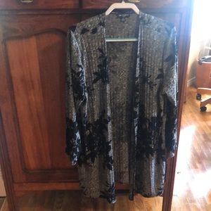 Longer black and gray sweater with long sleeves. No buttons